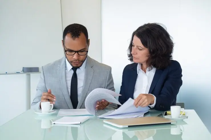 A commercial lawyer reviewing papers at a glass table
