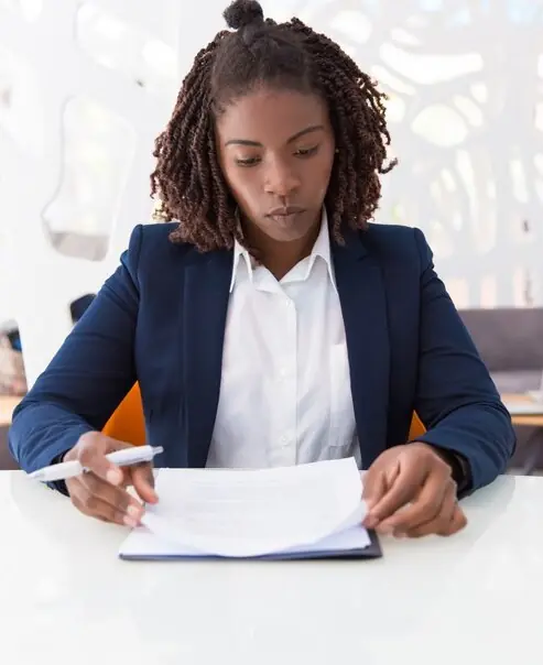 A lawyer reading a contract at her desk