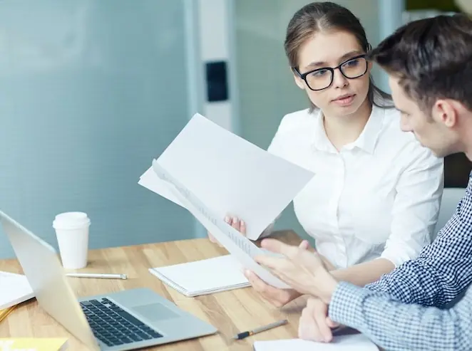 Two colleagues going through a printed contract together