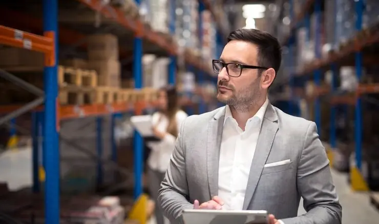 A procurement manager with a tablet in a warehouse