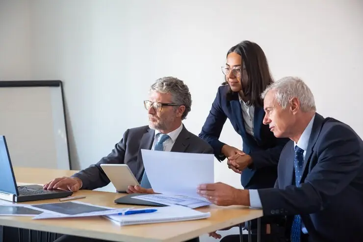 A small team in a working session around a laptop